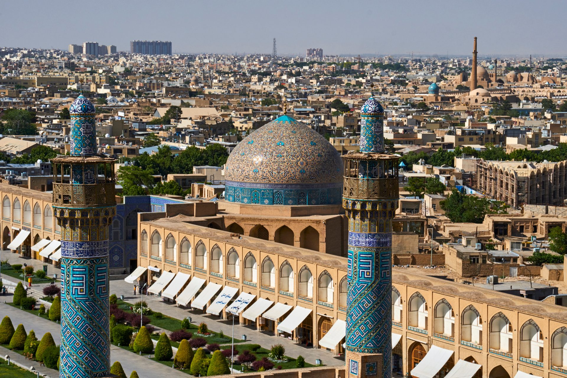 Das Bild zeigt die Stadtansicht von Isfahan mit der beeindruckenden Architektur der Imam-Moschee (Masjid-e Imam), einschließlich ihrer charakteristischen blauen Fliesen und der großen Kuppel.